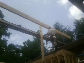 Carpenter setting a ridge beam over a new addition frame — Ice Dam Removal by Roofing Brothers in Delevan