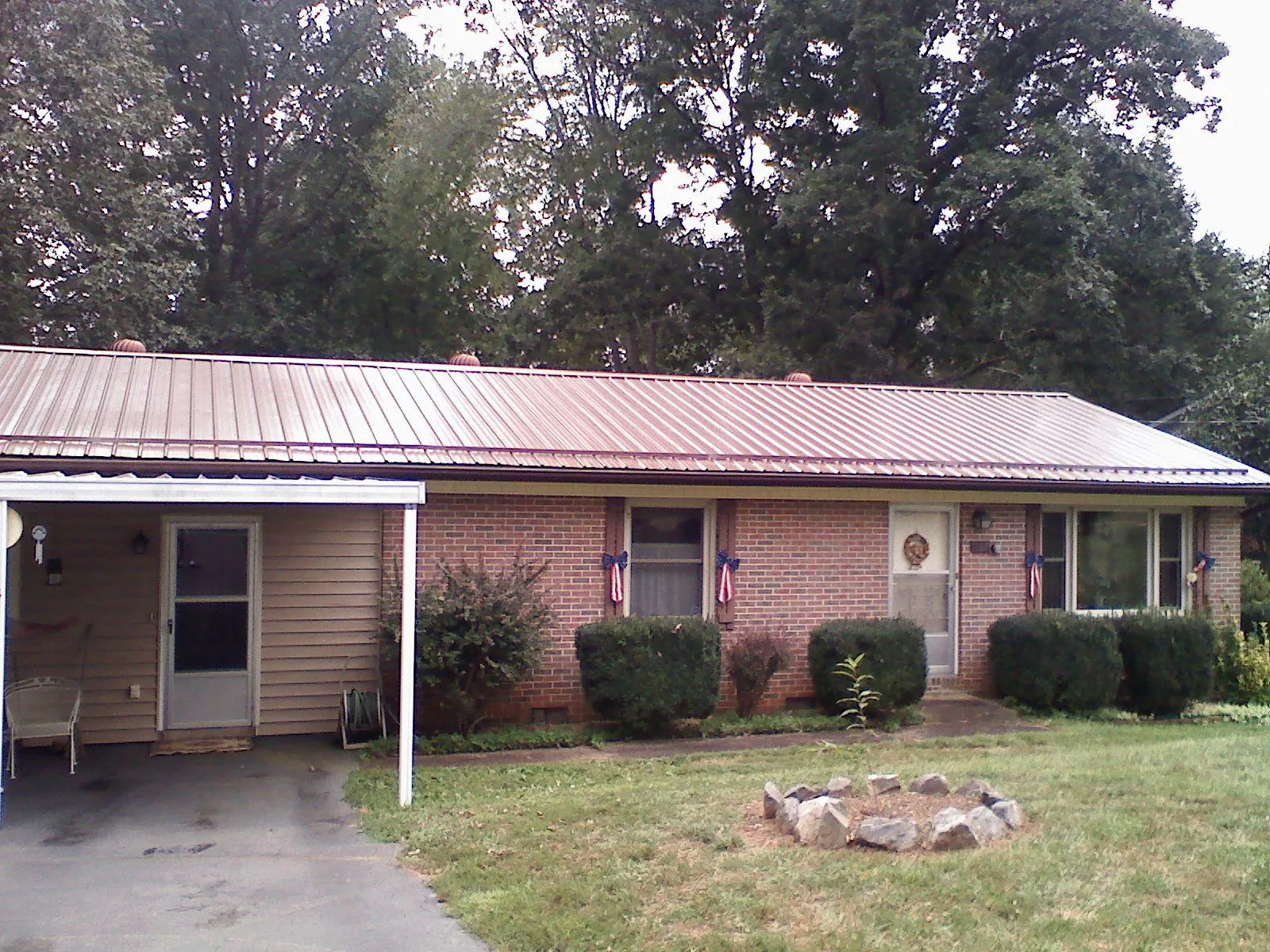 Bronze metal roof and carport on a brick ranch home — Roof Repair work by our crew in Delevan